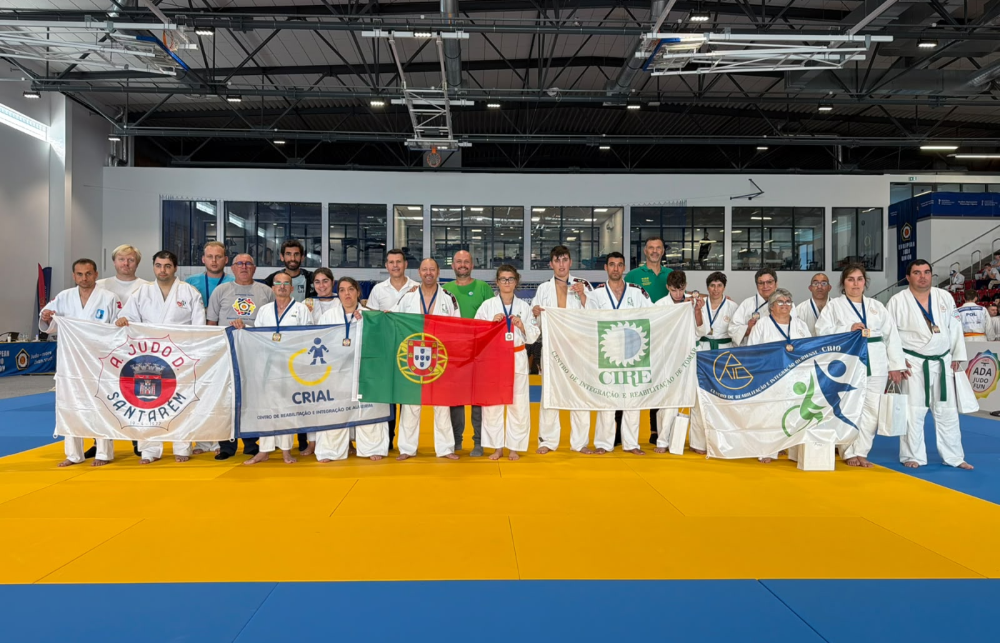 Delegação de cinco entidades de Judo Adaptado de Santarém com bandeiras em Gdańsk