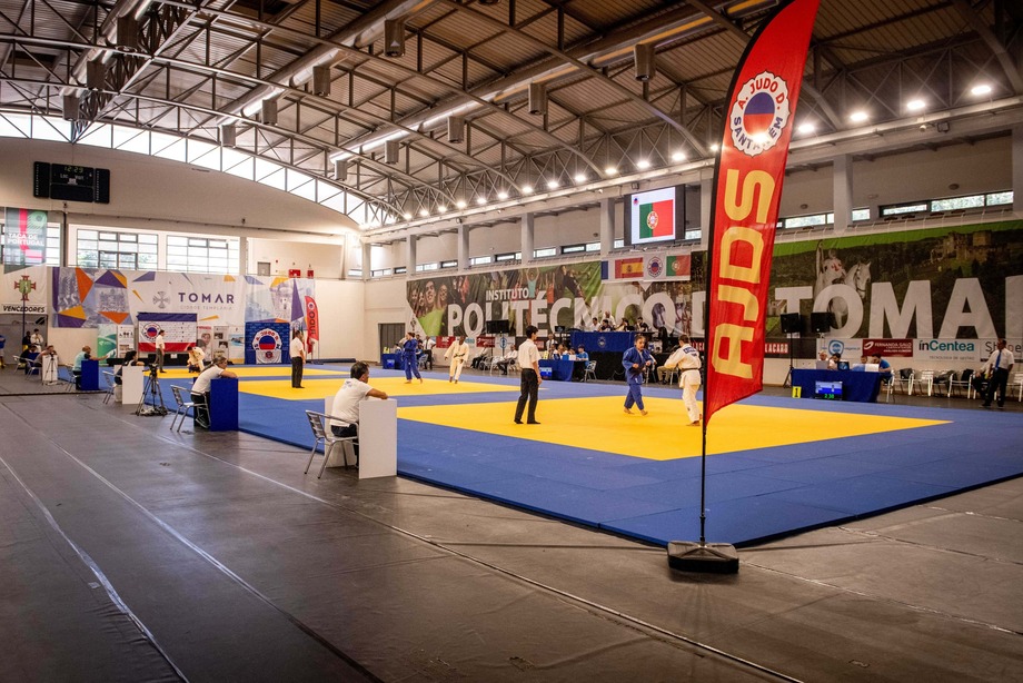 Tatami de competição da AJDS, com bandeira da associação em destaque