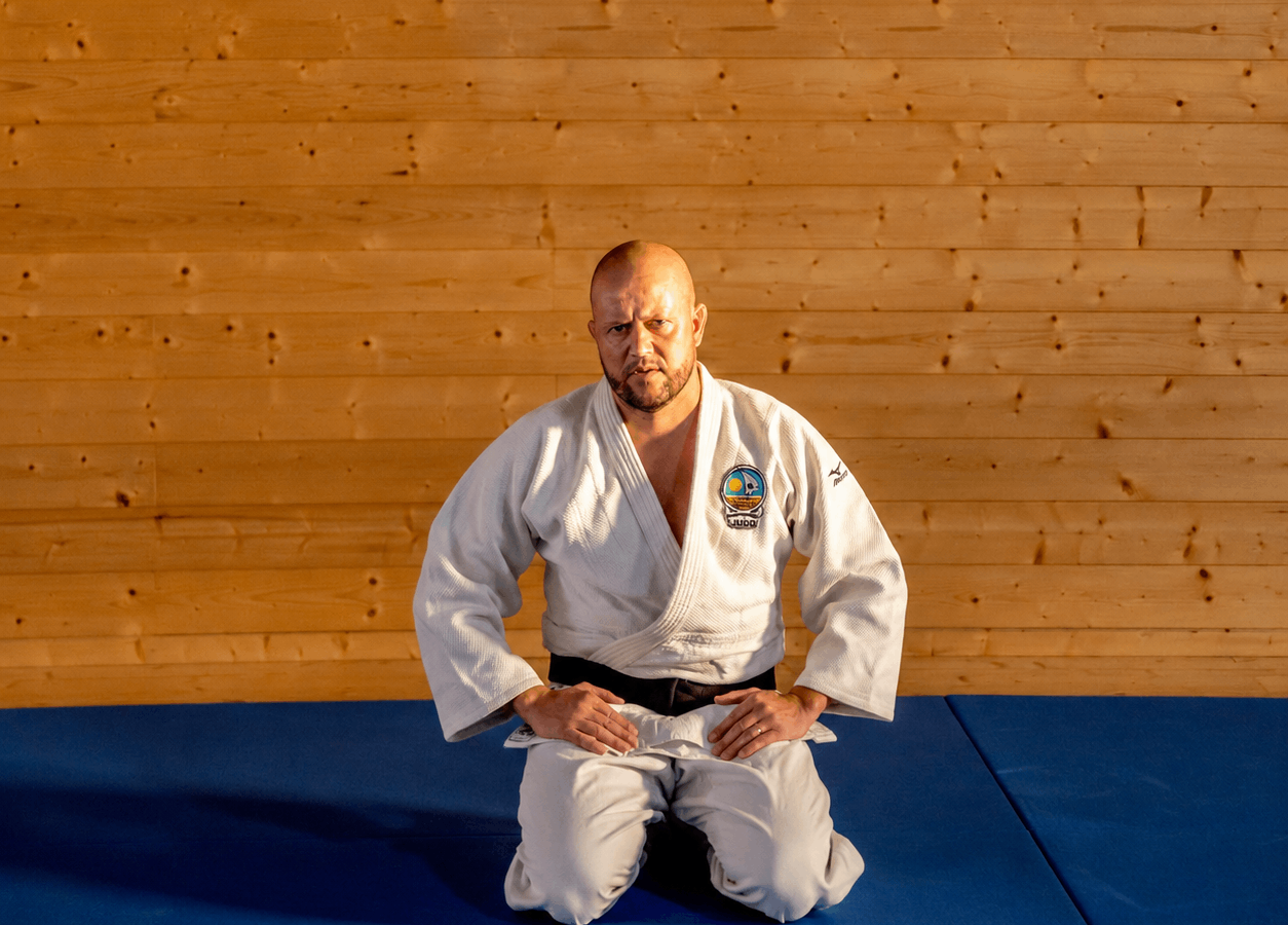 Dinis Pinto, Presidente da ADJA, ajoelhado no tatami, de judogi branco e cinto preto